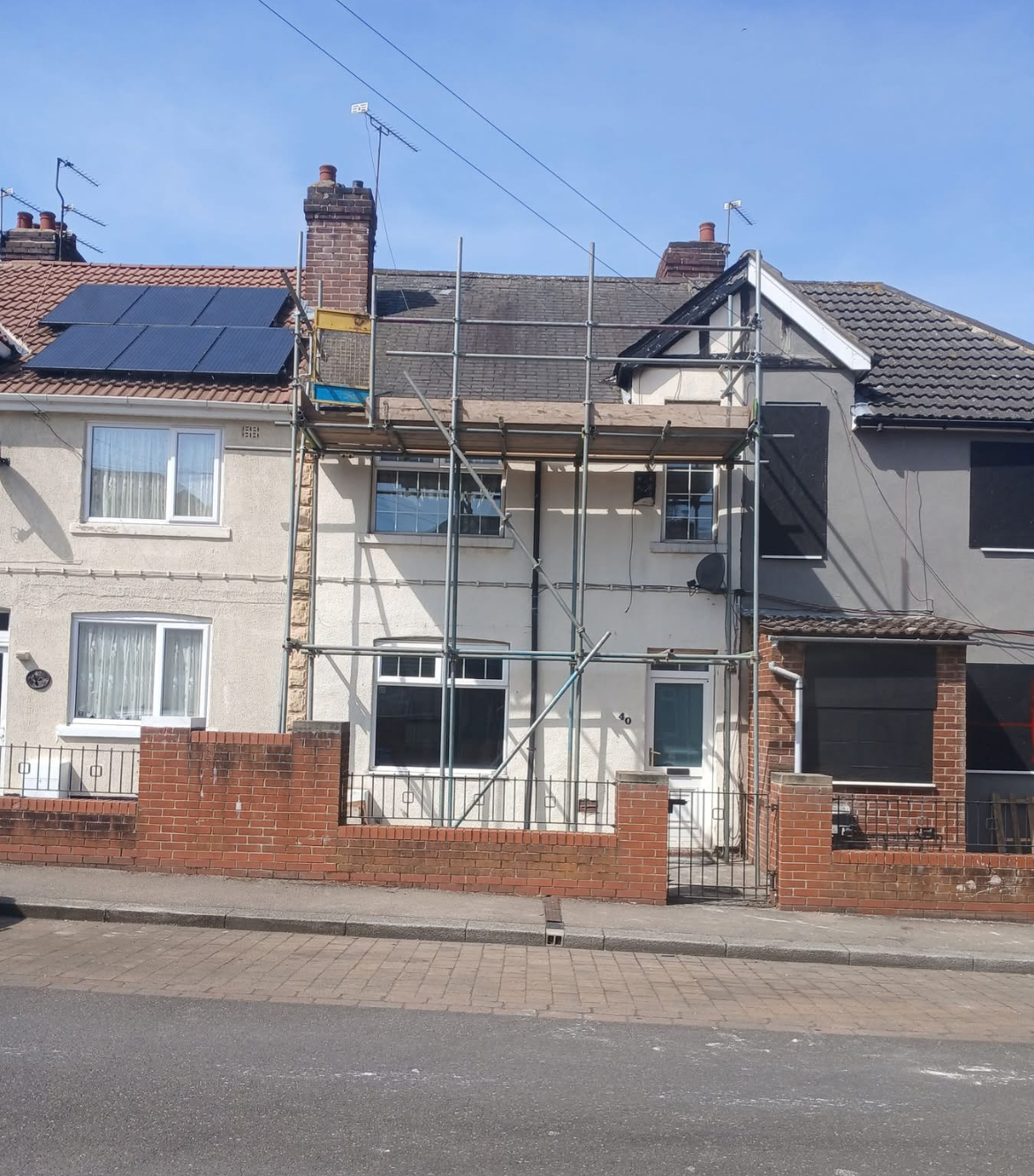 Roofing and exterior maintenance work in progress on a terraced house